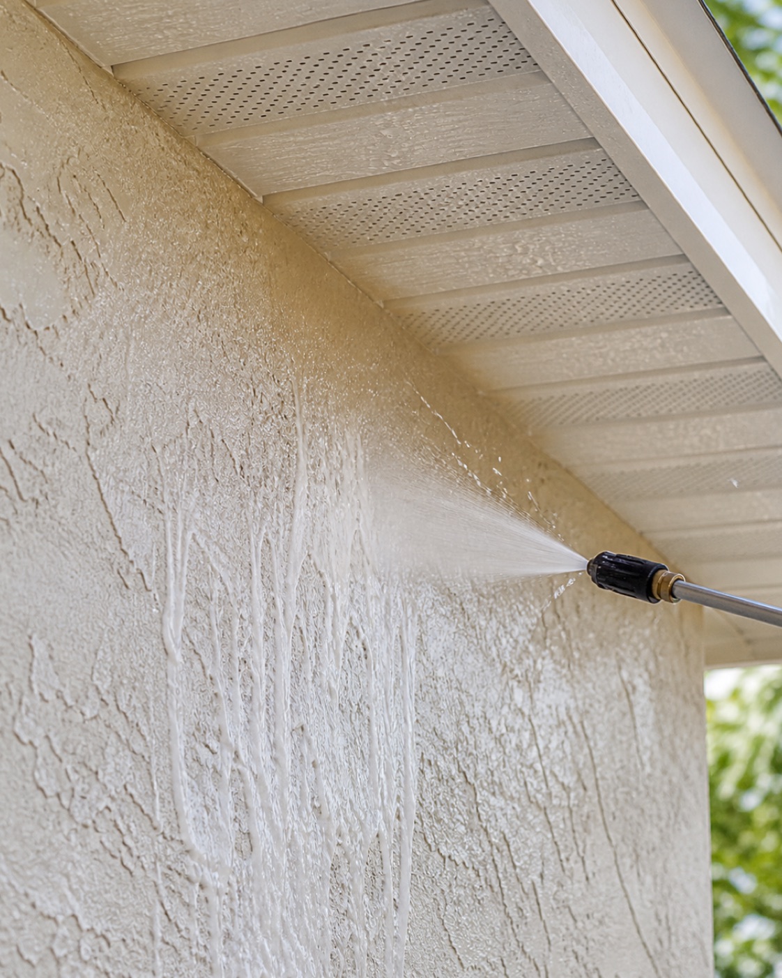 Low-pressure rinse removing wash solution from textured stucco and a clean soffit